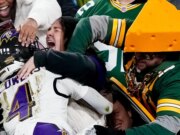 Un fan dei Packers spinge Zay Flowers, il ricevitore largo dei Ravens, durante la celebrazione del TD