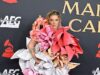Kesha attira l’attenzione con un stravagante abito ornato di fiori giganti mentre cammina a piedi nudi sul tappeto rosso al Gala di Persona dell’anno di MusiCares in vista dei Grammy 2026