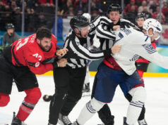 Il canadese Tom Wilson lascia cadere i guanti con il francese Pierre Crinon alle Olimpiadi