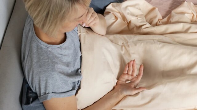 person-taking-pill-in-bed.jpg